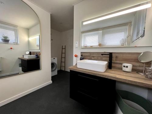 a bathroom with a white sink and a mirror at Les deux maisons - Roz - Appartement Gérardmer vue pistes proche lac in Gérardmer