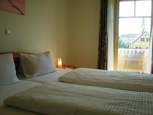 two beds in a hotel room with a window at Rebenlandhof in Leutschach