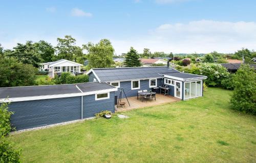a blue house with a deck and a yard at 4 Bedroom Cozy Home In Middelfart in Middelfart