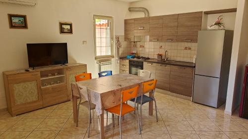 a kitchen with a table with chairs and a refrigerator at Borgo & Mare in San Donato