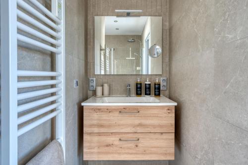 a bathroom with a sink and a mirror at Maison des Marais 5 Etoiles La Chaume Piscine in Les Sables-dʼOlonne