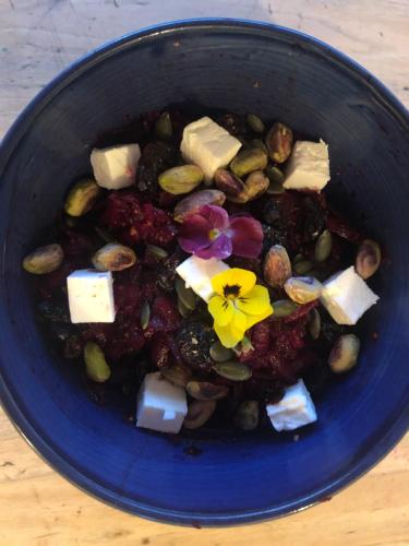 a blue bowl of food with cheese and a flower in it at El refugio in Reynès