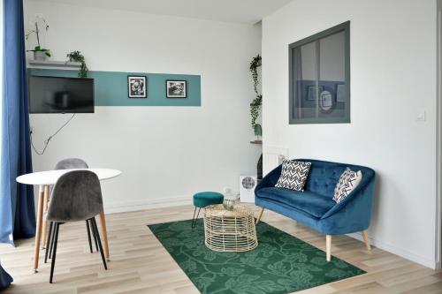 un salon avec une chaise bleue et une table dans l'établissement Studio Armorique Recouvrance, à Brest