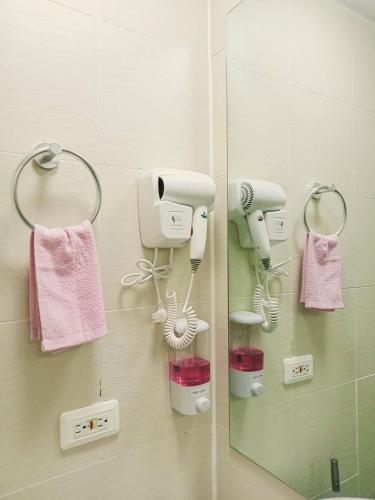 a bathroom with two hair dryers and a mirror at Sam's Chic Space - An Aesthetic Getaway in Angeles