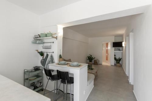 a kitchen and living room with a counter and stools at Margarita Studios Ambelas in Ambelas