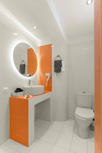 a bathroom with a toilet and a sink and a mirror at Margarita Studios Ambelas in Ambelas