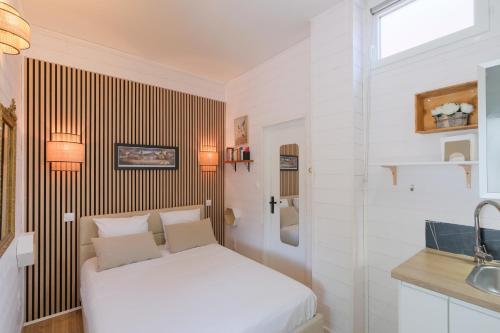 - une chambre blanche avec un lit et un lavabo dans l'établissement Les Suites d'Aliénor, Suite Jasmin, à Pessac