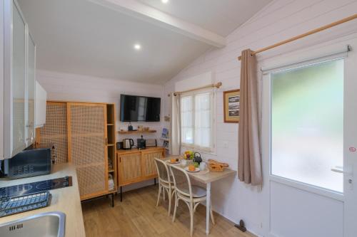 a kitchen with a table and chairs and a window at Les Suites d'Aliénor, Suite Jasmin in Pessac