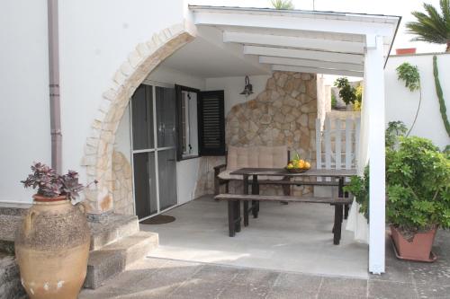 a patio with a wooden table and an umbrella at TERRA DI MARE LOC. TURISTICA in Vignacastrisi