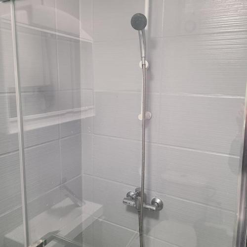 une douche avec une porte vitrée dans une salle de bain dans l'établissement Appartement T1 place Kéruscun, à Brest