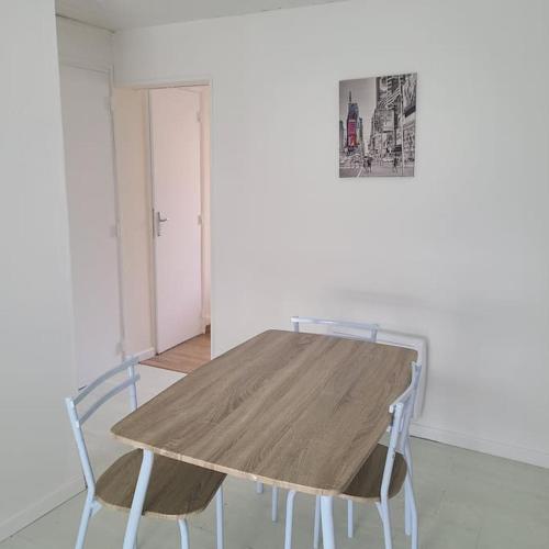 - une table en bois et 2 chaises dans une chambre dans l'établissement Appartement T1 place Kéruscun, à Brest