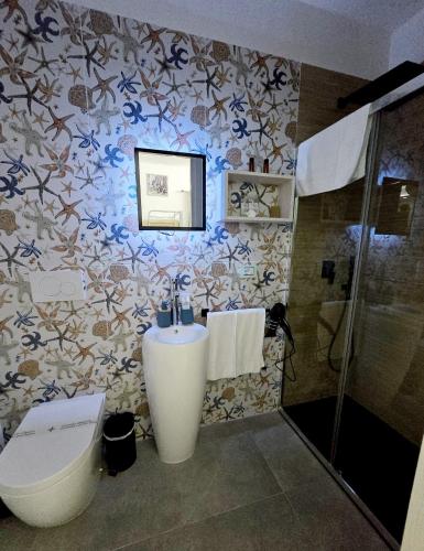 a bathroom with a sink and a toilet and a shower at Aquamarina Rooms in Porto Cesareo