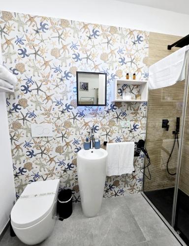 a bathroom with a white toilet and a sink at Aquamarina Rooms in Porto Cesareo