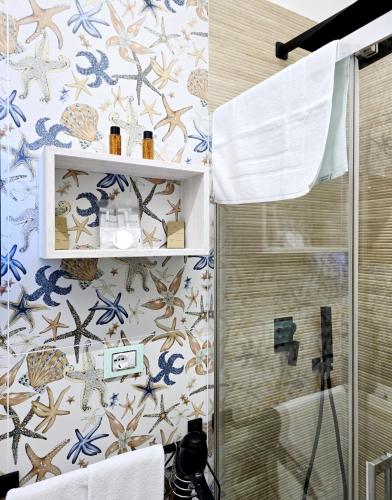 a bathroom with a shower with blue and white tiles at Aquamarina Rooms in Porto Cesareo