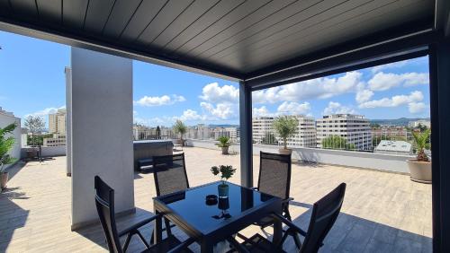 a patio with a table and chairs on a balcony at Zadar Sunset Penthouse with spectacular view and jacuzzi in Zadar