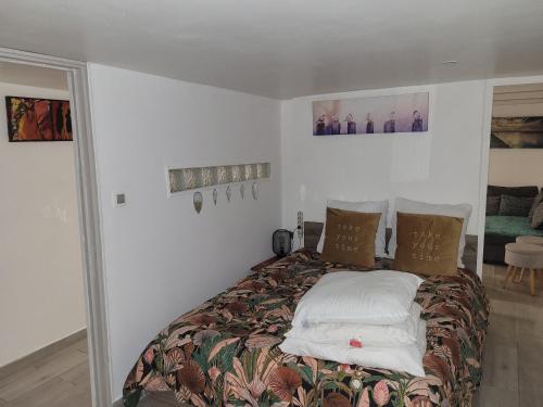 une chambre avec un grand lit avec des oreillers dans l'établissement Joli rez de jardin, à La Seyne-sur-Mer