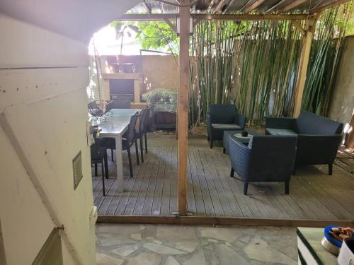 une terrasse avec une table et des chaises ainsi qu'une salle à manger dans l'établissement Joli rez de jardin, à La Seyne-sur-Mer