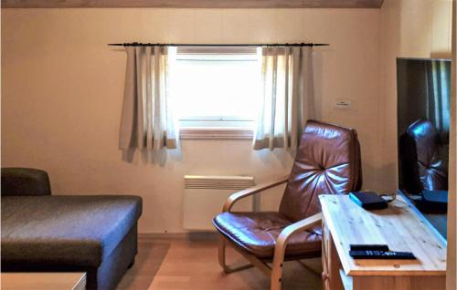a living room with a chair and a desk and a window at Hytte 1 in Øvre Ramse