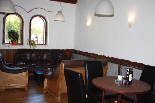 a waiting room with a leather couch and tables at Hotel Britz in Velké Hamry