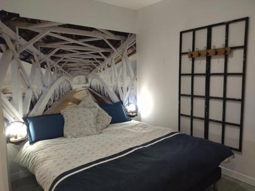 un lit blanc avec des oreillers bleus dans une chambre dans l'établissement La villa des six ifs - La glycine, à Flayosc