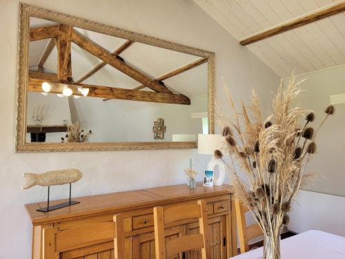 - une salle à manger avec un miroir et une table dans l'établissement Maison Paisible, à Saint-Jean-de-Monts