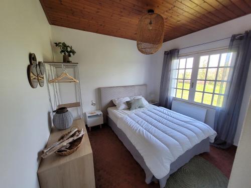 une chambre avec un grand lit et une fenêtre dans l'établissement Maison Paisible, à Saint-Jean-de-Monts
