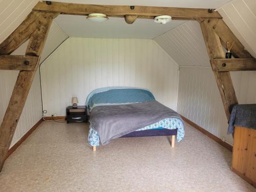 une chambre avec un lit dans un grenier dans l'établissement Gîte à Romagné, à Romagné