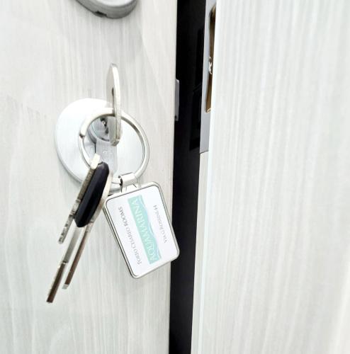 a key on a door with a tag on it at Aquamarina Rooms in Porto Cesareo