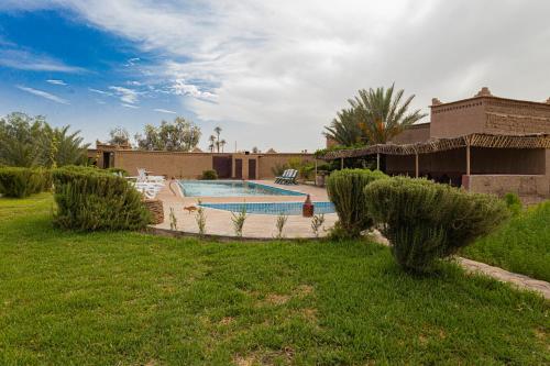 a house with a swimming pool in a yard at Maison D'hôte Amridil in Skoura