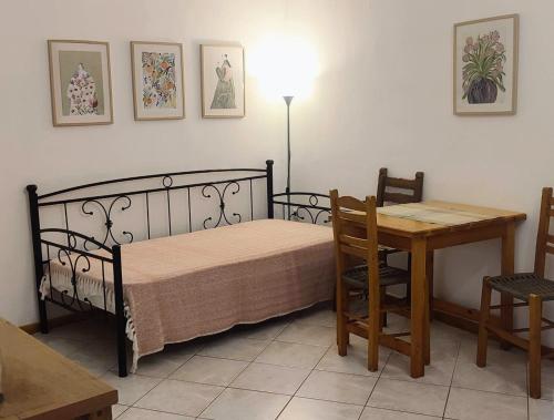 a bedroom with a bed and a table and a table and chairs at Maroudas Stavros Apartments in Vathi, Ithaka