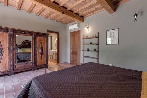 a bedroom with a bed and a wooden cabinet at comfortable private villa with pool San Giuseppe Tramontana in Montecatini Val di Cecina
