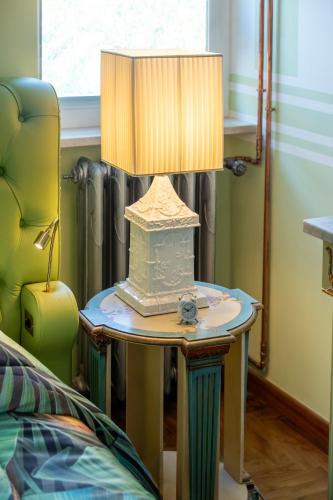 a lamp on a table next to a bed at Regal House Anzio Manetti 16 in Anzio