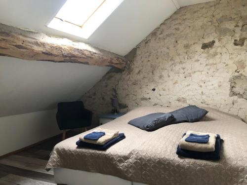 a bedroom with a bed with towels on it at Maison Bonheur Resort Bousset in Chiddes