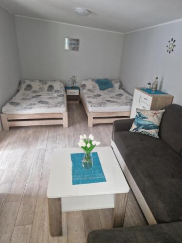 a living room with three beds and a table at Leśny Zakątek - Domek Morze in Ustka