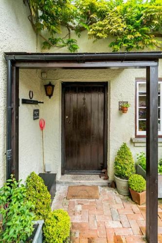 a front door of a house with a red balloon at Cedra Cottage - Vintage Country Hideaway in Axminster