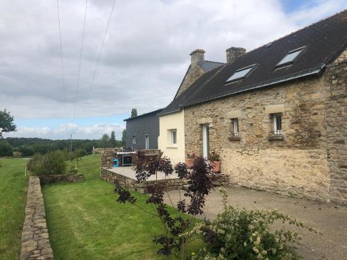 una vista exterior de una casa de piedra con patio en Gîtes du Clos du Ratz, en Arradon