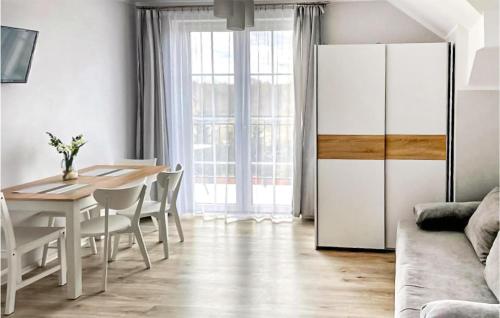 カルビアにあるGorgeous Apartment In Karwiaのダイニングルーム(テーブル、白い冷蔵庫付)