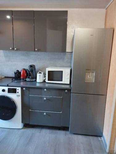 une cuisine avec un réfrigérateur et un micro-ondes dans l'établissement Appartement Brest Keruscun, à Brest
