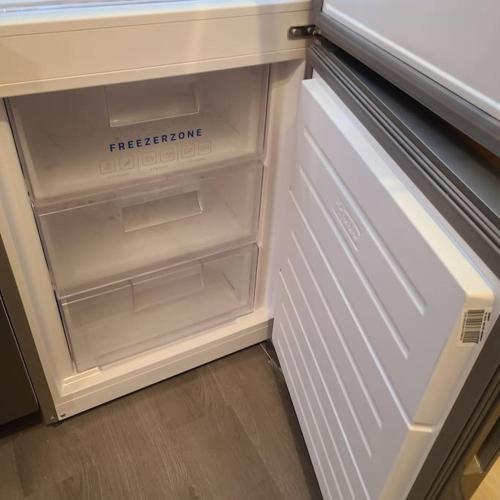 un réfrigérateur vide avec sa porte ouverte dans une cuisine dans l'établissement Appartement Brest Keruscun, à Brest