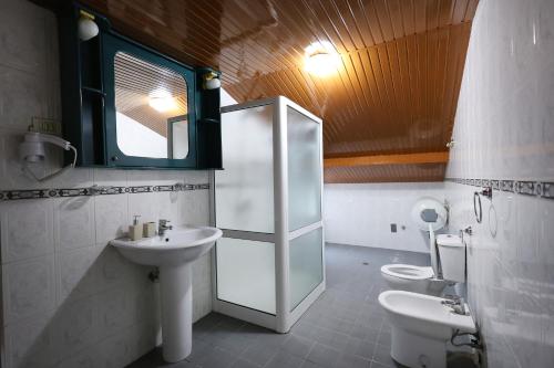 a bathroom with two toilets and a sink and a mirror at Vila Spahiu in Berat