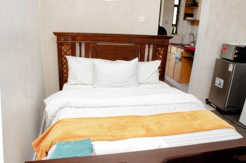 a bed with a wooden headboard in a room at Studio Apartment near the Airport in Nairobi