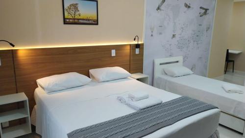 two beds in a room with white sheets at VISION HOTEL Brasilia Piscina Academia Garagem Flat 12 Andar in Brasília