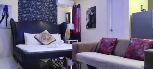 a room with a couch and a bed and a chair at Jack Kandi Grosvenor Square in Angeles