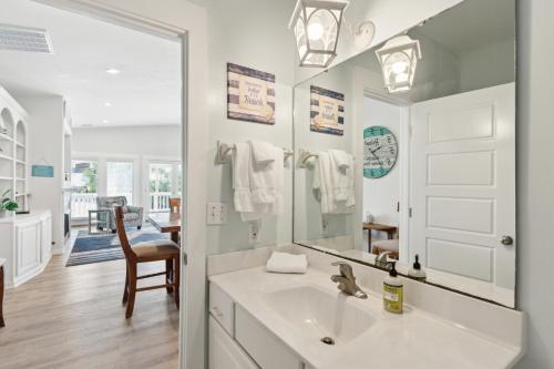 un bagno bianco con lavandino e specchio di Down River a Edisto Island