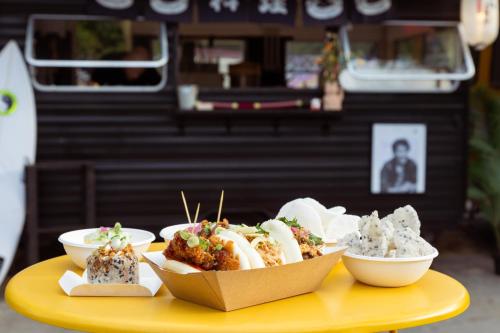 a yellow table with bowls of food on it at JO&JOE Hossegor in Hossegor