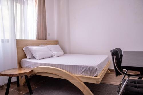 a bed in a room with a table and a chair at Studio Apartment near the Airport in Nairobi