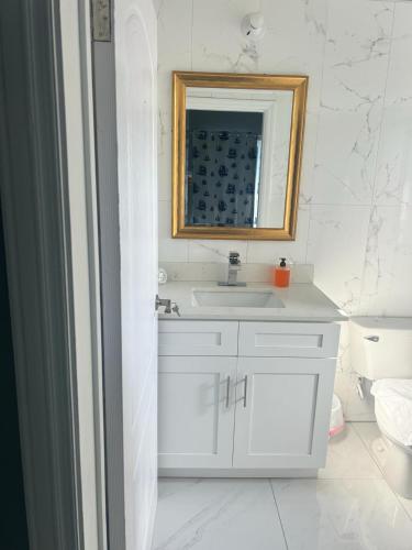 a bathroom with a white sink and a mirror at Paradise Point Company Limited in Treasure Beach