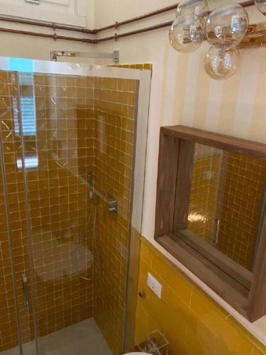 a bathroom with a shower with a glass door at Regal House Anzio Manetti 16 in Anzio