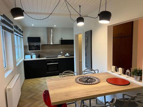 une cuisine et une salle à manger avec une table et des chaises en bois dans l'établissement Les deux maisons - Le 68 - Appartement et balcon vue pistes proche lac, à Gérardmer