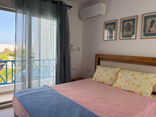 a bedroom with a bed and a large window at Mountain view North Coast Ras elhekma, Tart's Home, Families only in Ras Elhekma